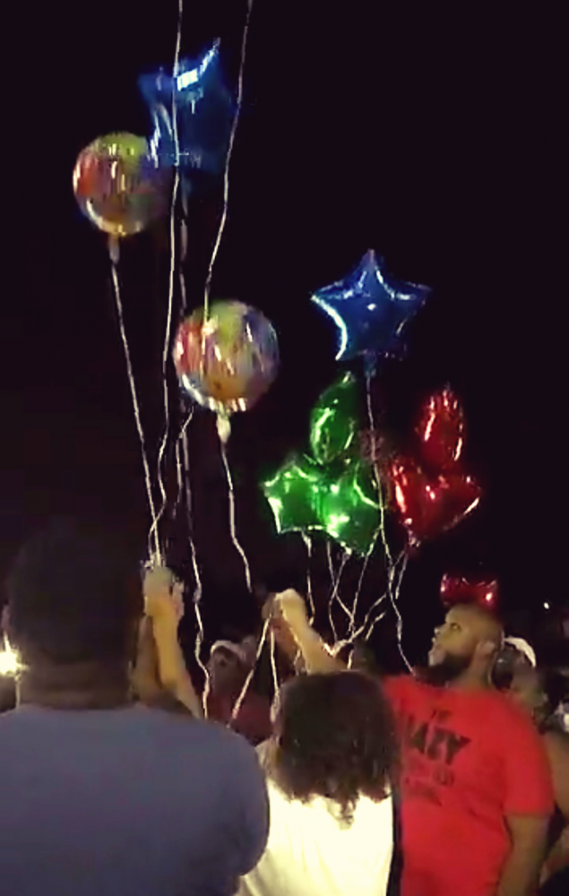 Hillcrest students and alumni release balloons in memory of Mr. Keith Anderson.