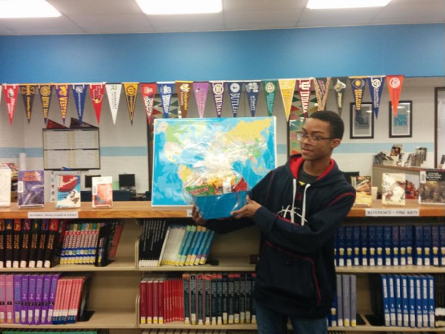 Pictured with the raffle basket in front of the “Where in the World” display is Bryan Ingram, a student in Ms. Erin Johnson’s French 1 class. 