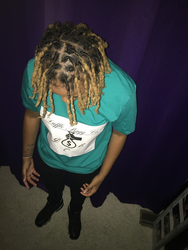 Kappa wears black timberland boots, black pants, and a green shirt from her line: Duffle Bagg Co.

(Photo by Essence Knighten-EL)
